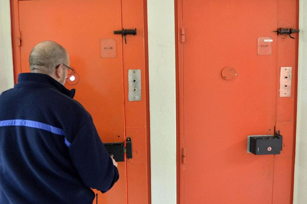 Photo d'un gardien de prison, ouvrant la porte de la cellule d'un détenu