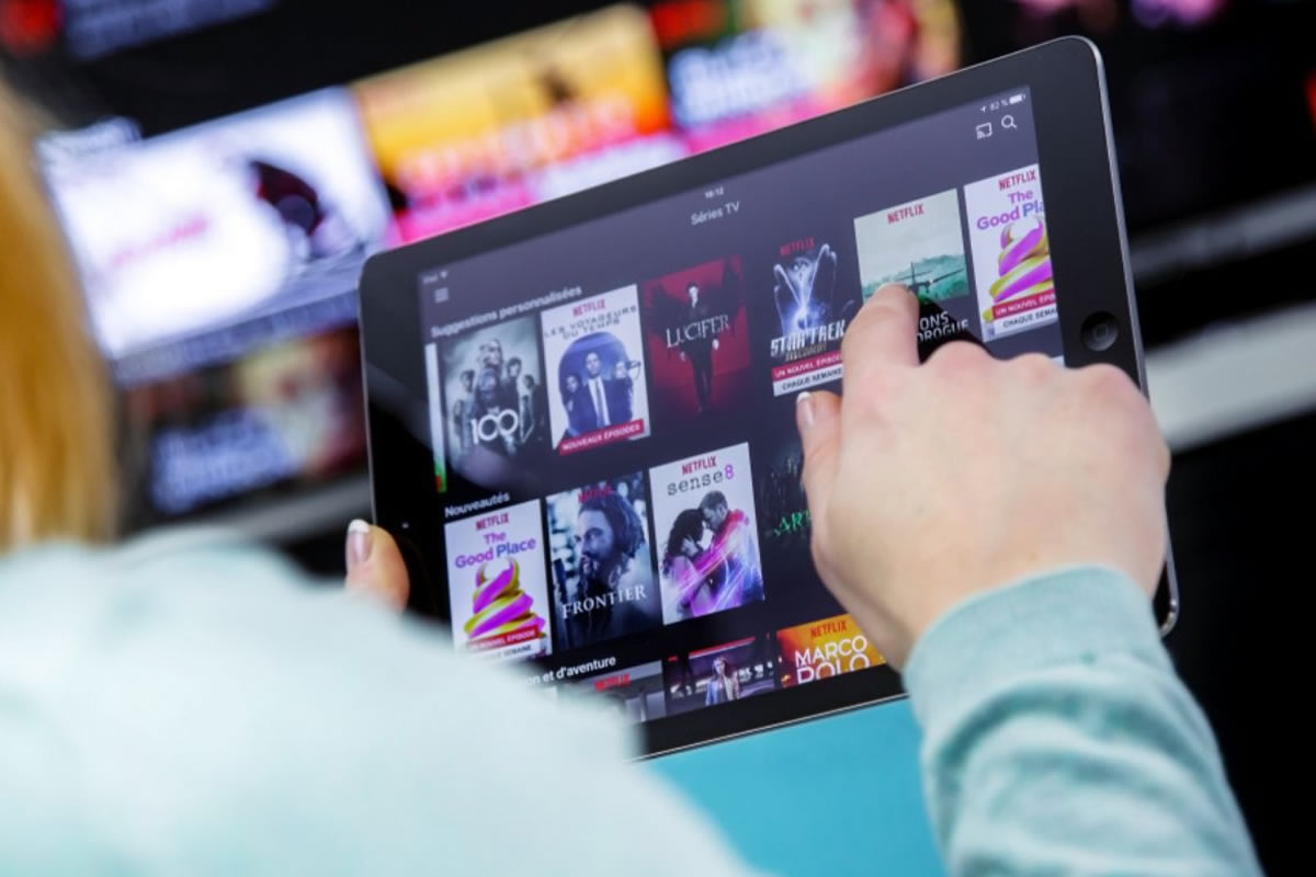 Photo d'un femme navigant sur une plateforme de streaming, pour trouver du contenu