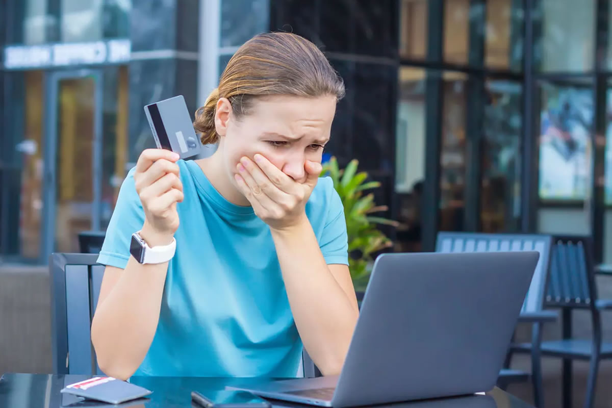 Photo d'une jeune femme victime d'une fraude financière face à son ordinateur