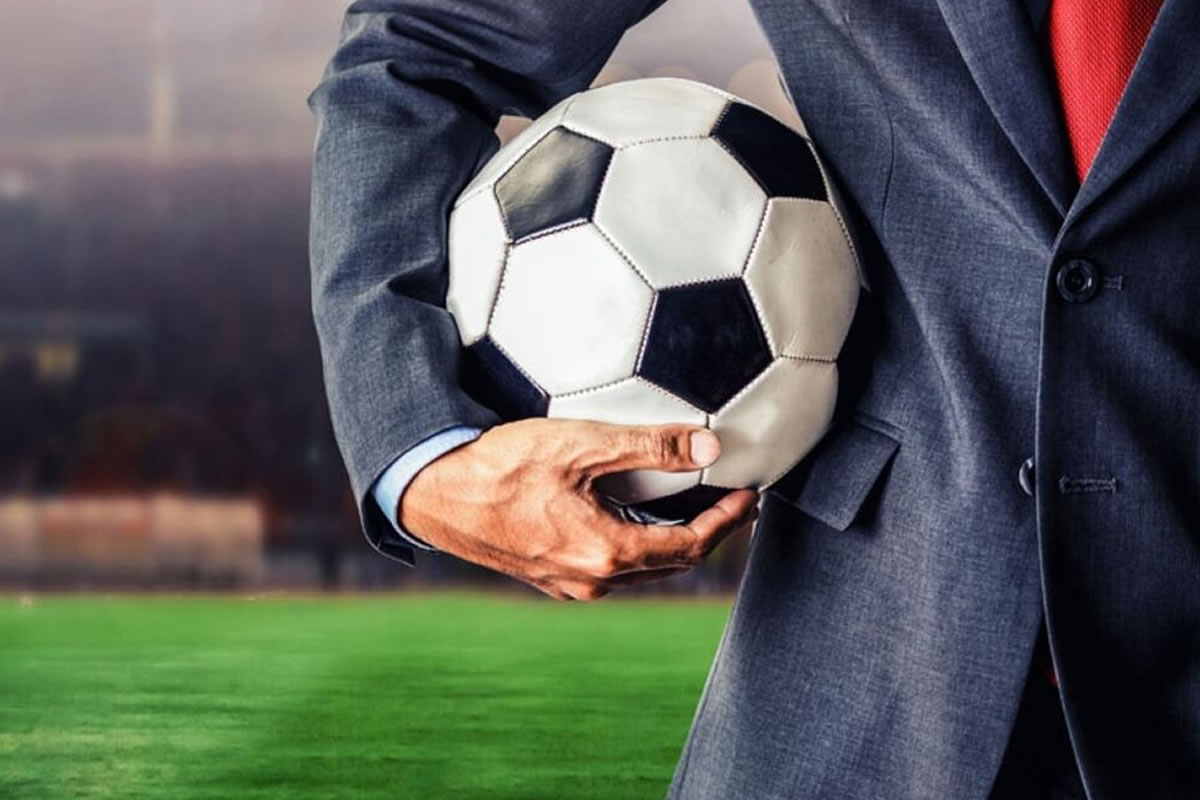 Photo d'un agent de joueurs de football avec un ballon sous le bras, au mercato